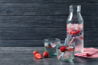 Photo of Natural lemonade with berries in glassware on table