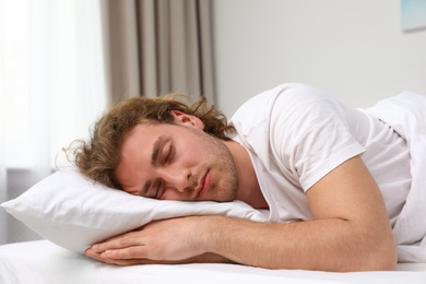 Photo of Handsome young man sleeping on pillow at home. Bedtime