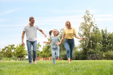 Photo of Happy family running in park on summer day