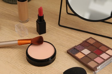 Mirror and cosmetic products on wooden dressing table, closeup