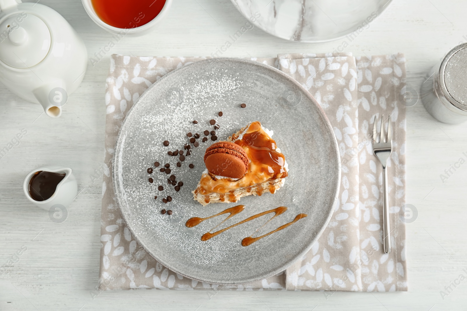 Photo of Piece of delicious homemade cake with caramel sauce on table, top view