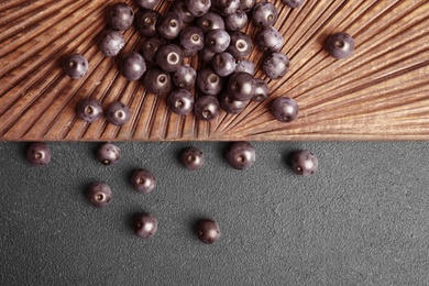 Photo of Fresh acai berries on wooden board, top view