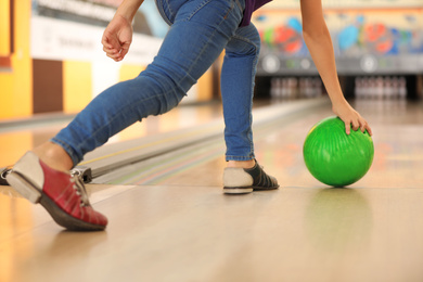 Photo of Child throwing ball in bowling club, closeup