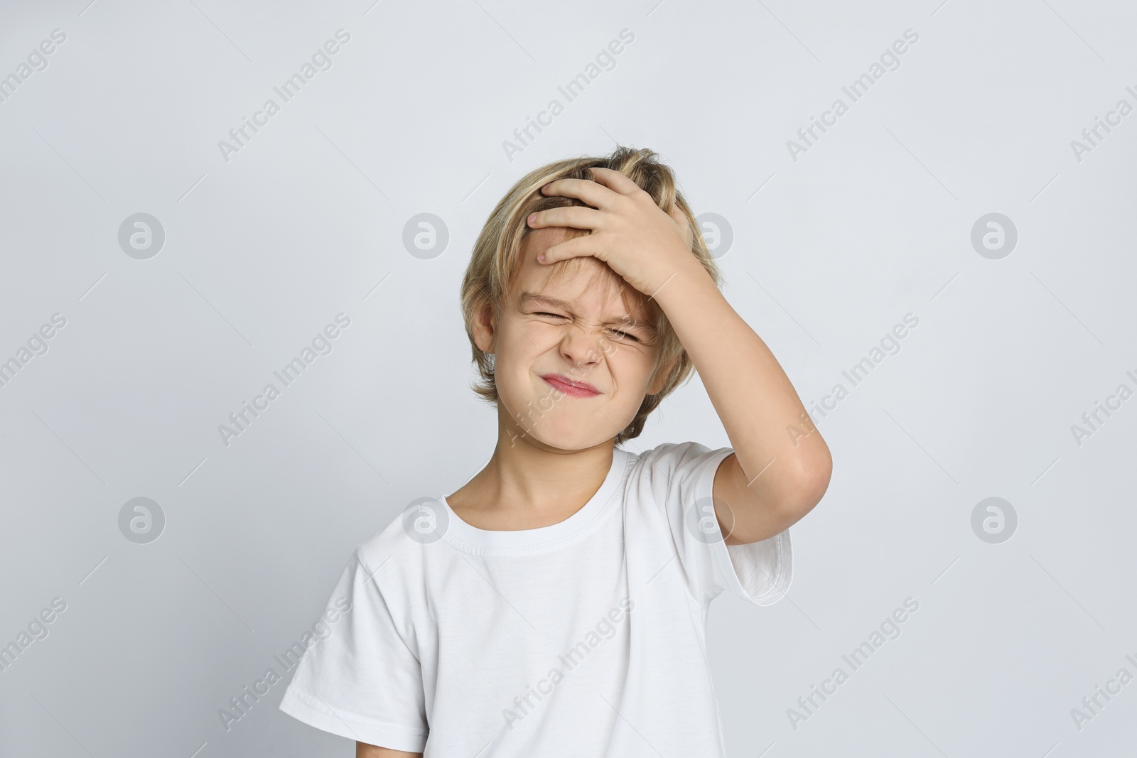 Photo of Unhappy little boy on light grey background