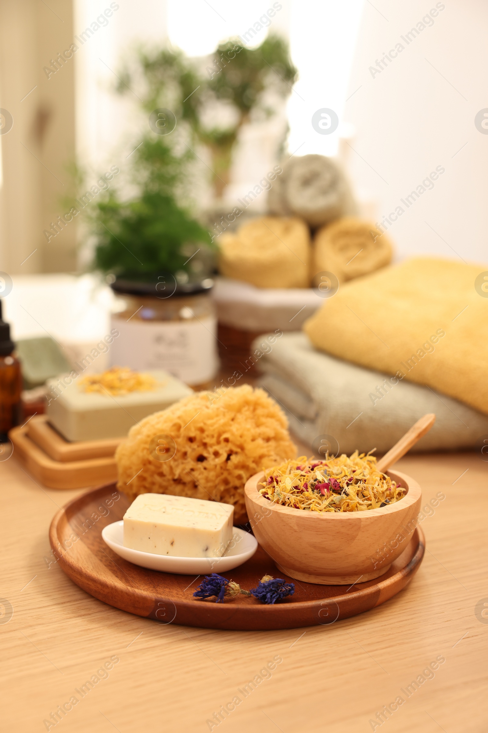 Photo of Dry flowers, loofah and soap bar on wooden table indoors, space for text. Spa time