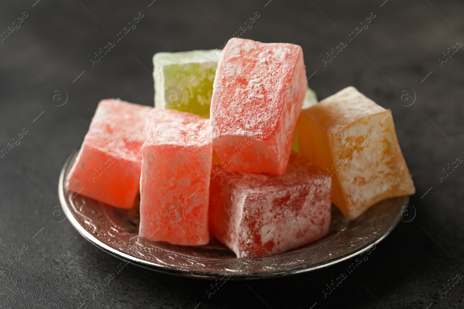 Photo of Turkish delight dessert on dark table, closeup