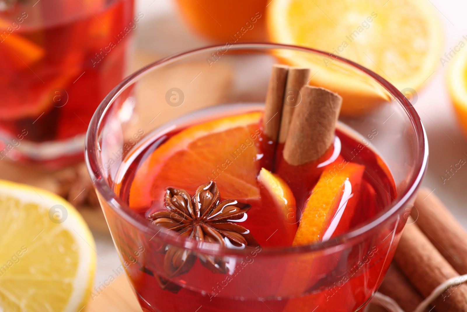 Photo of Glass of aromatic punch drink on table, closeup