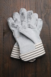 Photo of Pair of color gardening gloves on wooden table, top view