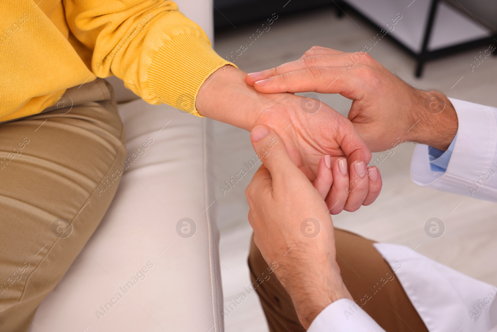 Photo of Doctor checking patient's pulse in clinic, closeup