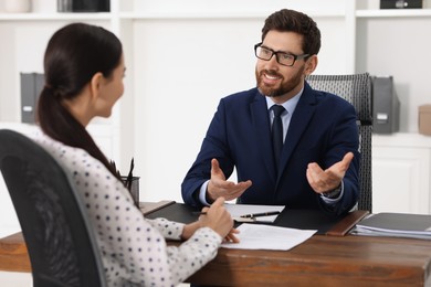 Woman having meeting with lawyer in office, selective focus