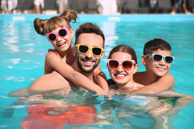 Happy family in swimming pool on sunny day