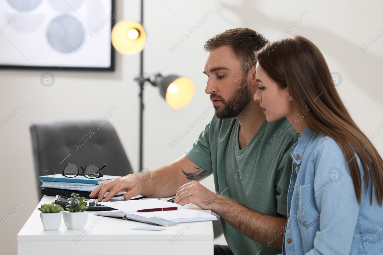 Photo of Young couple discussing family budget at home