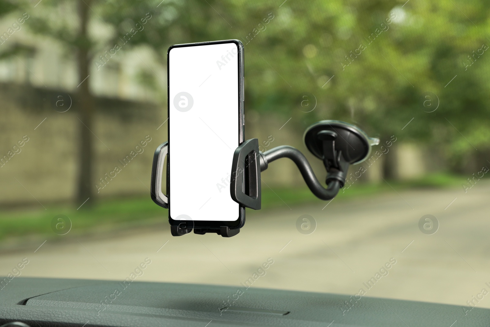 Photo of Car holder with modern mobile phone on windshield of automobile. Mockup for design