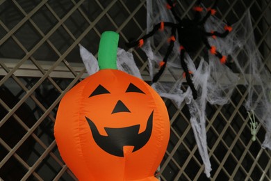 Photo of Toy Jack o'lantern and spider on window grid, space for text. Halloween decor