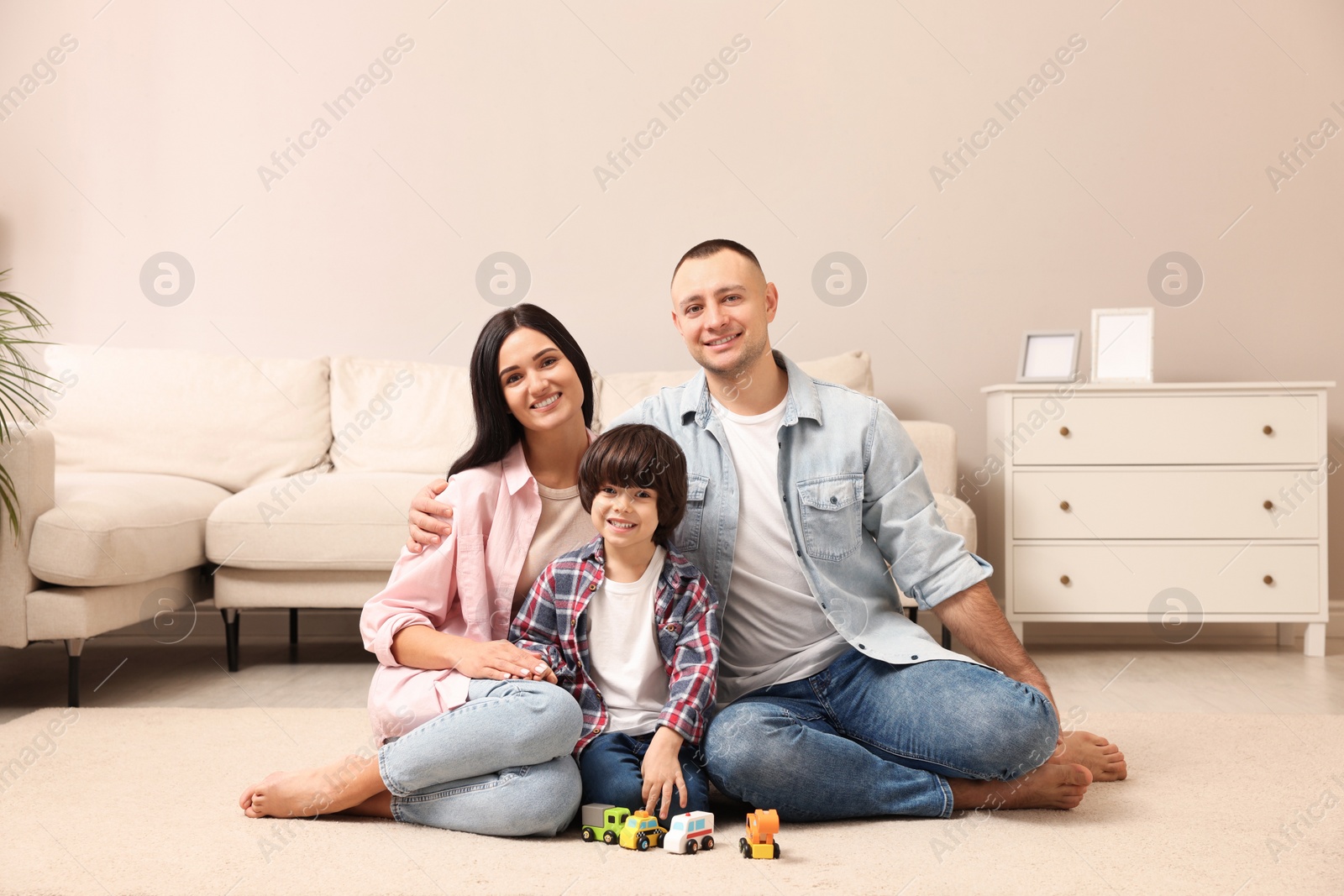 Photo of Happy family sitting on floor at home