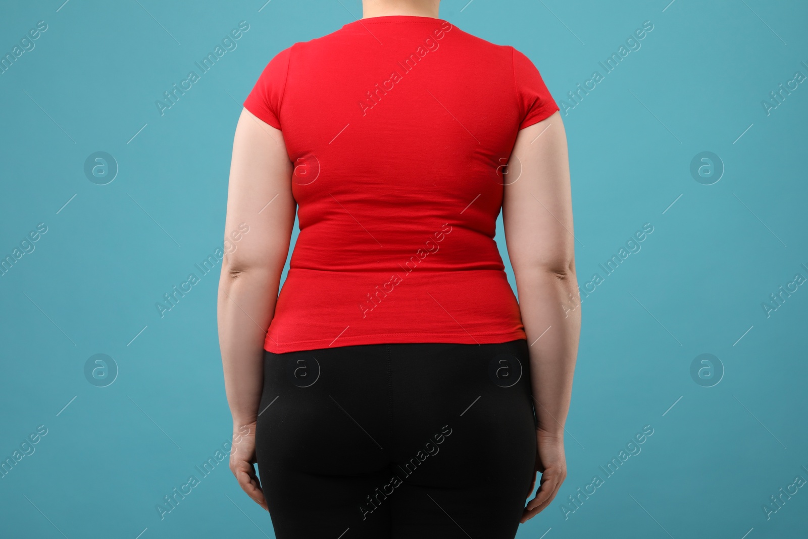 Photo of Overweight woman on light blue background, back view