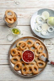 Photo of Flat lay composition with onion rings on wooden background