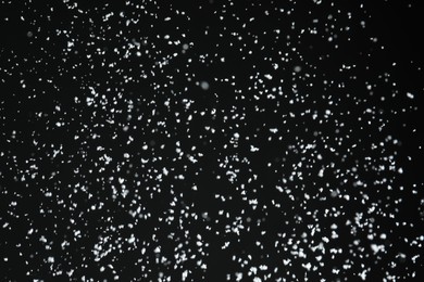 White snow falling down on black background