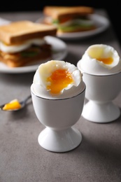 Photo of Soft boiled eggs served for breakfast on grey table, closeup