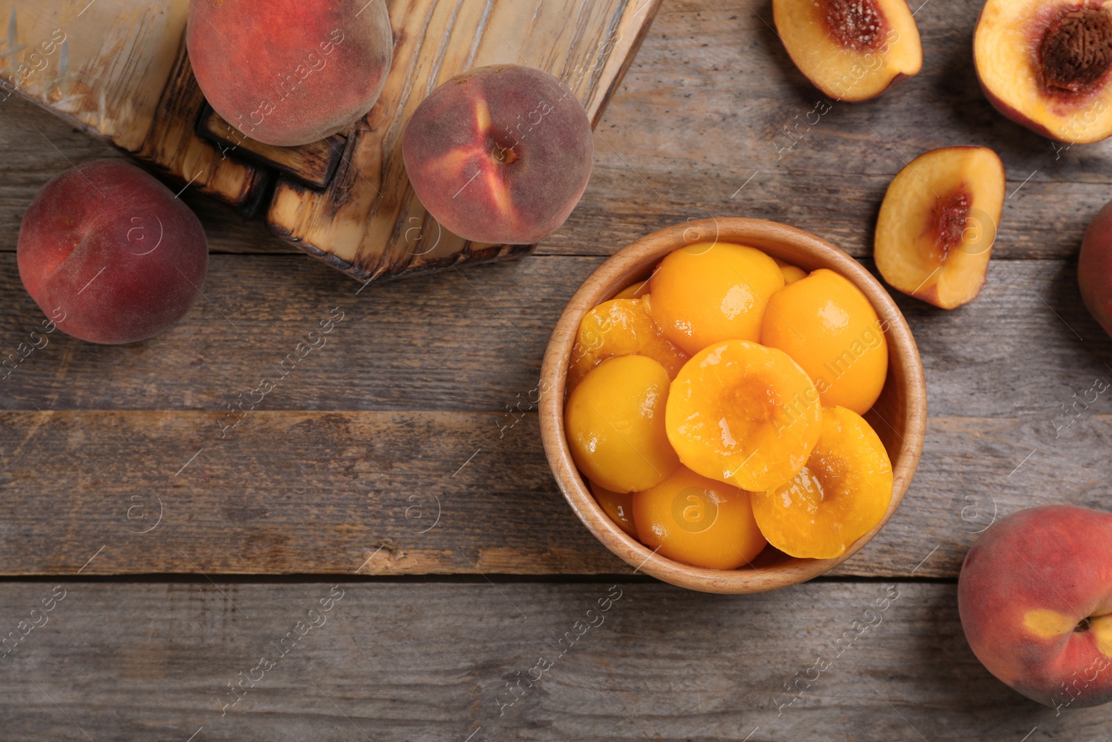 Photo of Flat lay composition with canned and fresh peaches on wooden background. Space for text