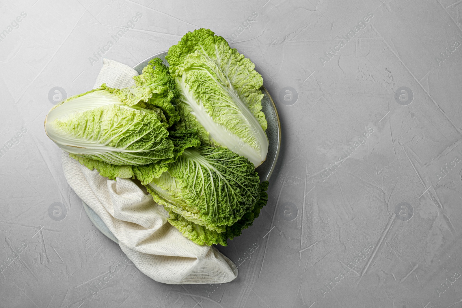 Photo of Fresh ripe Chinese cabbages on light grey table, top view. Space for text