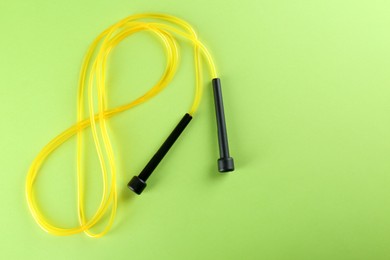 Photo of Skipping rope on light green background, top view. Space for text