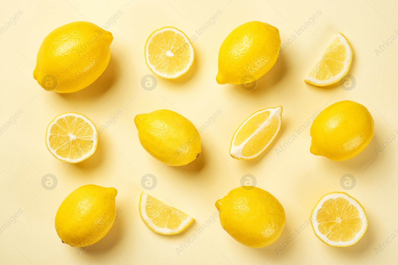 Photo of Flat lay composition with whole and sliced lemons on color background