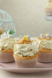 Tasty Easter cupcakes with vanilla cream on light wooden table