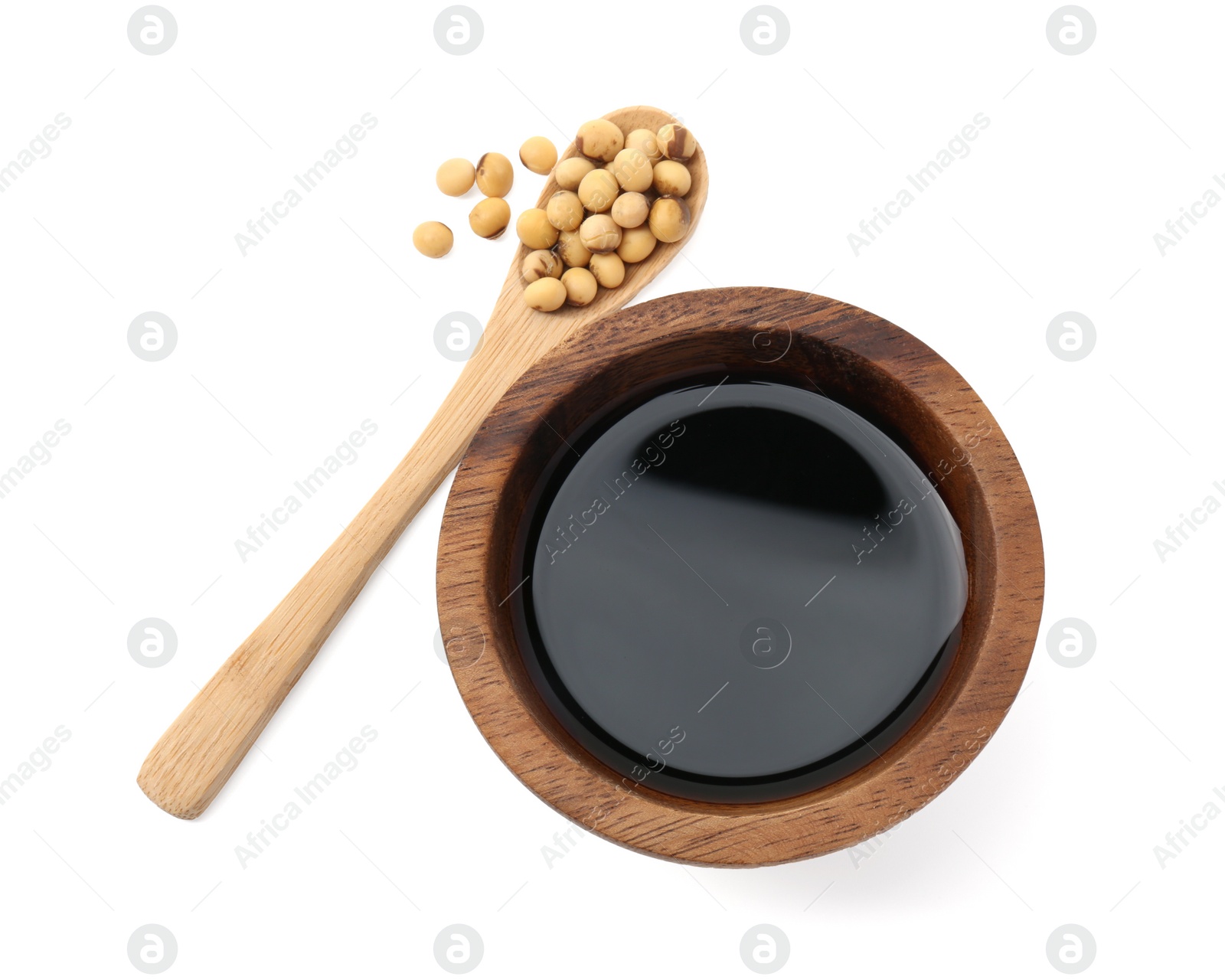 Photo of Tasty soy sauce in bowl, soybeans and spoon isolated on white, top view