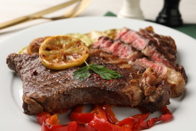 Photo of Delicious grilled beef steak and vegetables on plate, closeup