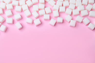 Photo of Refined sugar cubes on pink background, above view. Space for text