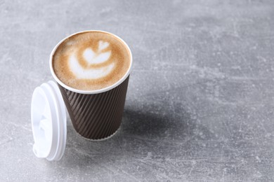 Photo of Coffee to go. Paper cup with tasty drink on grey table, space for text