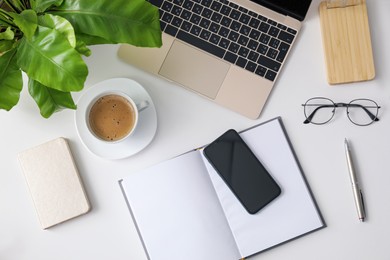 Photo of Office stationery, laptop and smartphone on white table, flat lay