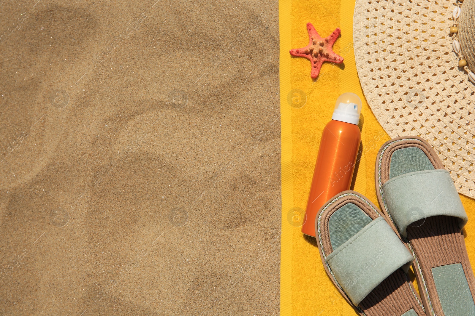 Photo of Sunscreen, starfish and beach accessories on sand, top view with space for text. Sun protection care