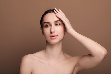 Photo of Portrait of beautiful young woman on brown background