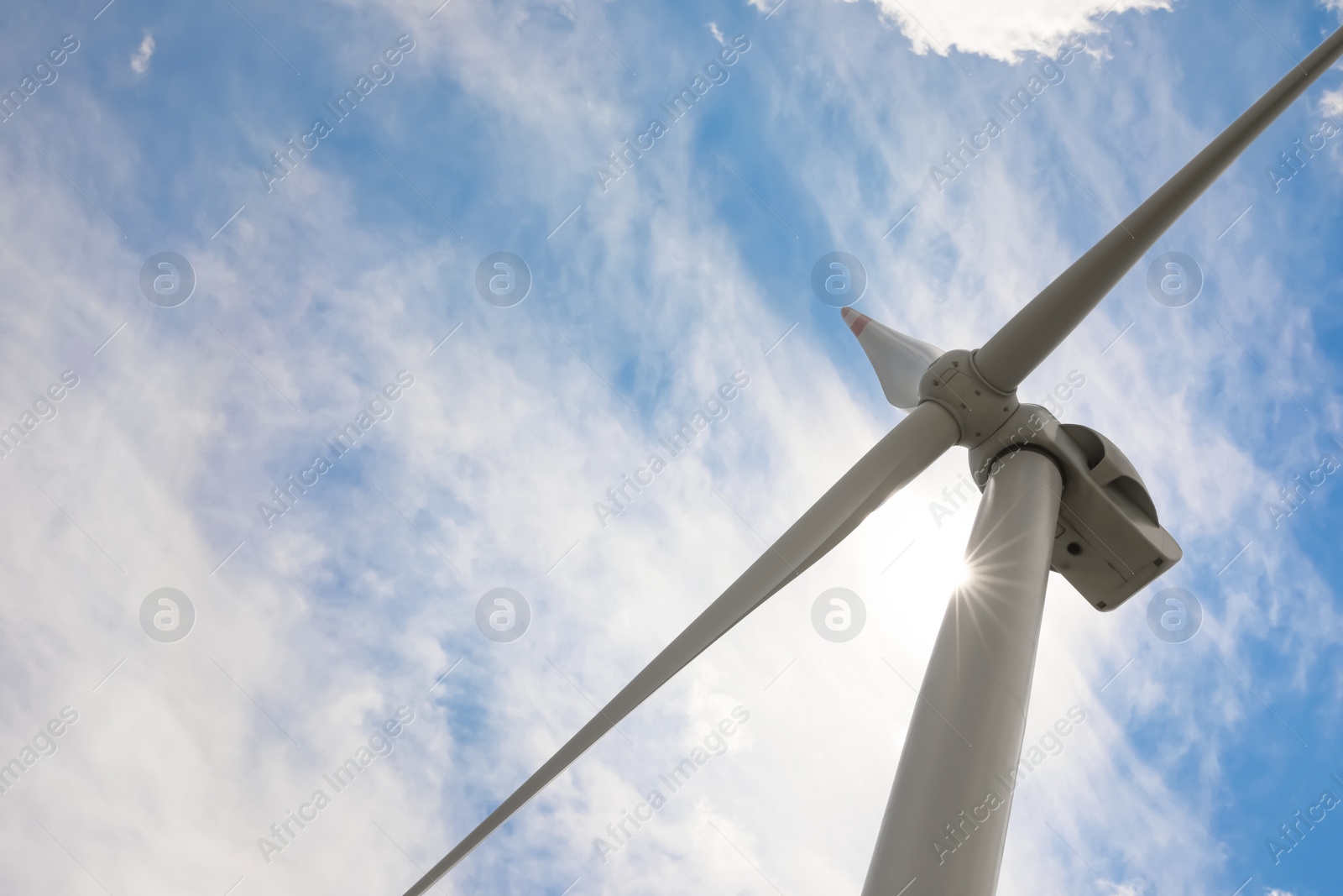 Photo of Modern wind turbine against cloudy sky, low angle view. Alternative energy source