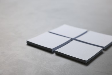 Blank paper sheets on grey textured table, closeup. Mockup for design