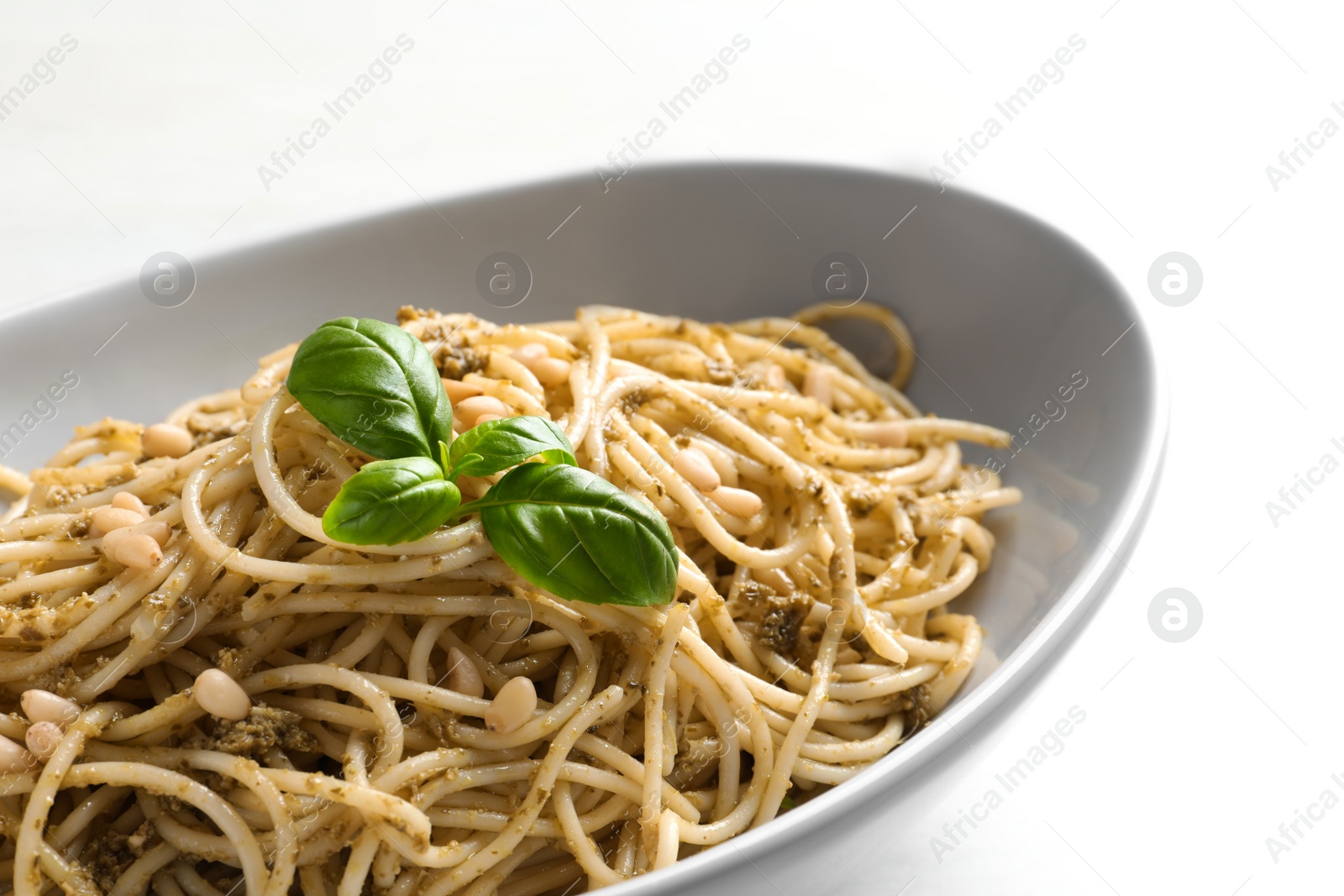 Photo of Plate of delicious basil pesto pasta on table