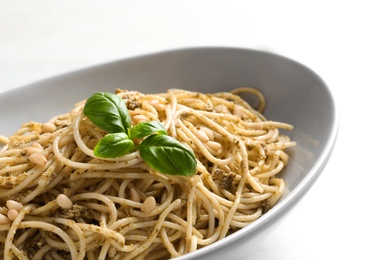 Plate of delicious basil pesto pasta on table