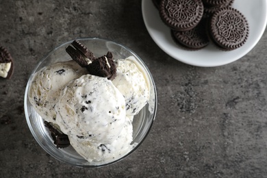 Photo of Bowl of chocolate cookies ice cream on grey background, top view with space for text