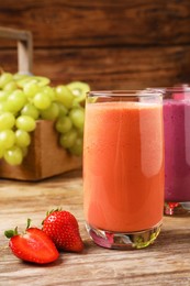 Glasses with tasty smoothies and ingredients on wooden table