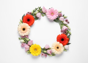 Photo of Wreath made of beautiful flowers and green leaves on white background, flat lay. Space for text