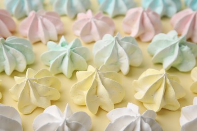 Delicious meringue cookies on beige background, closeup