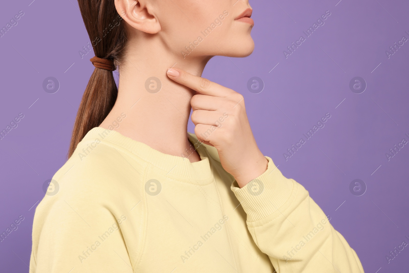 Photo of Woman with sore throat on violet background, closeup. Space for text