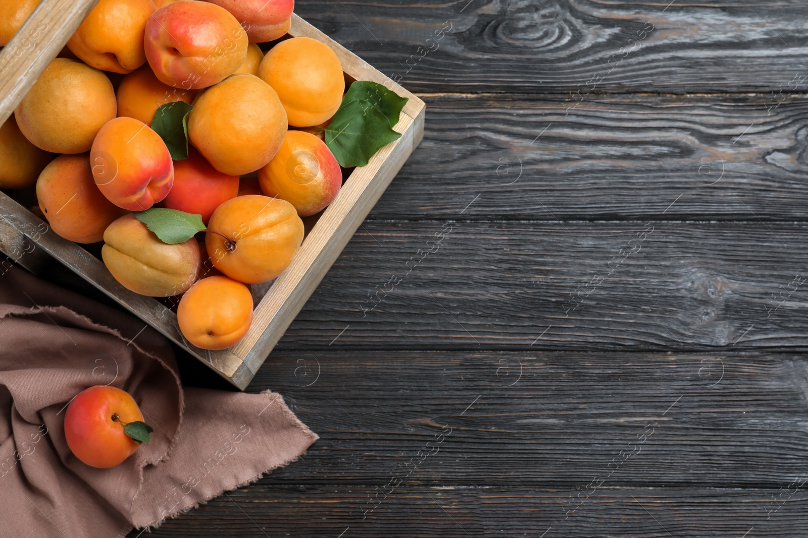 Photo of Many fresh ripe apricots on black wooden table, flat lay. Space for text