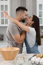 Photo of Affectionate young couple spending time together in kitchen