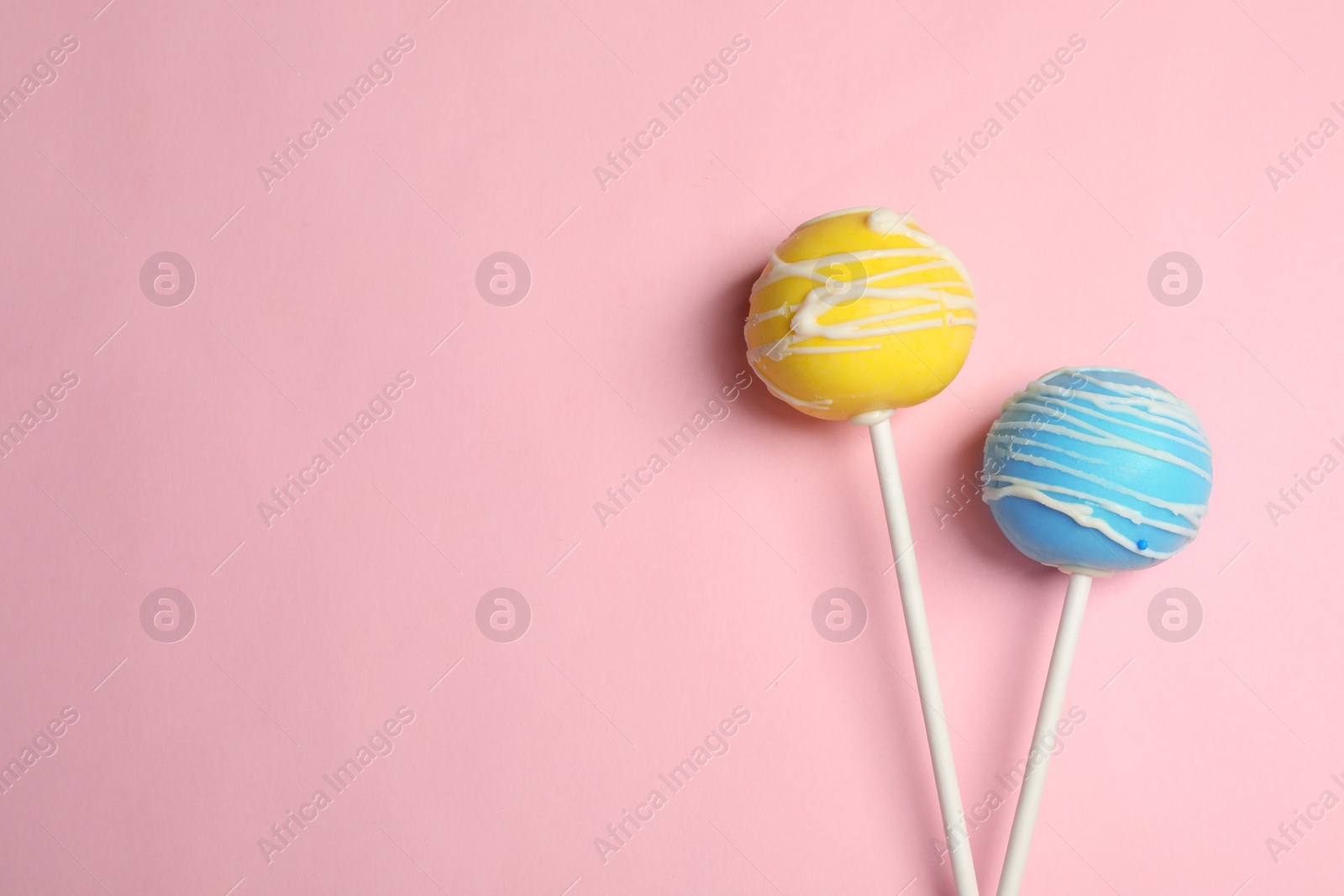 Photo of Bright delicious cake pops on color background, flat lay. Space for text