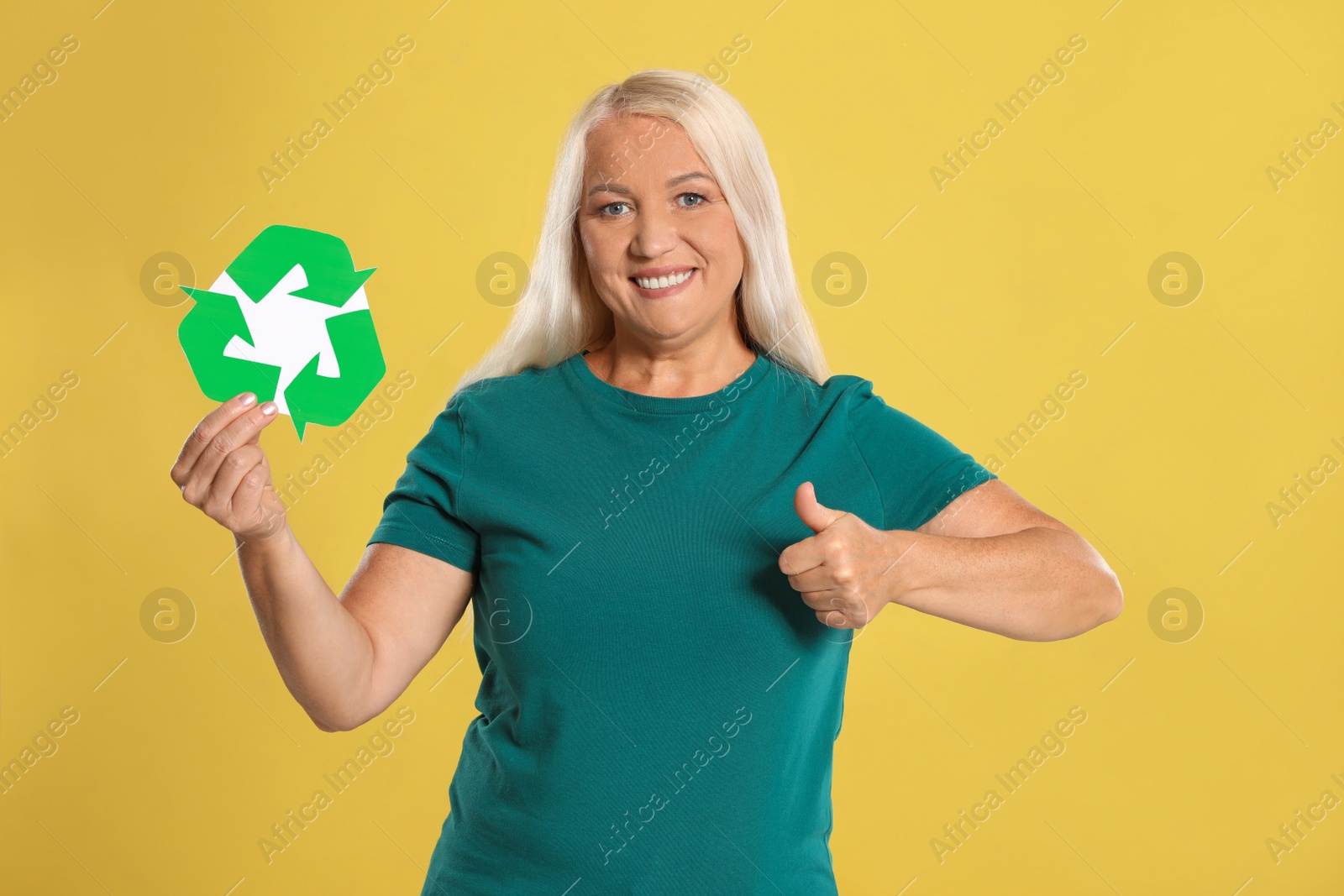 Photo of Woman with recycling symbol on yellow background