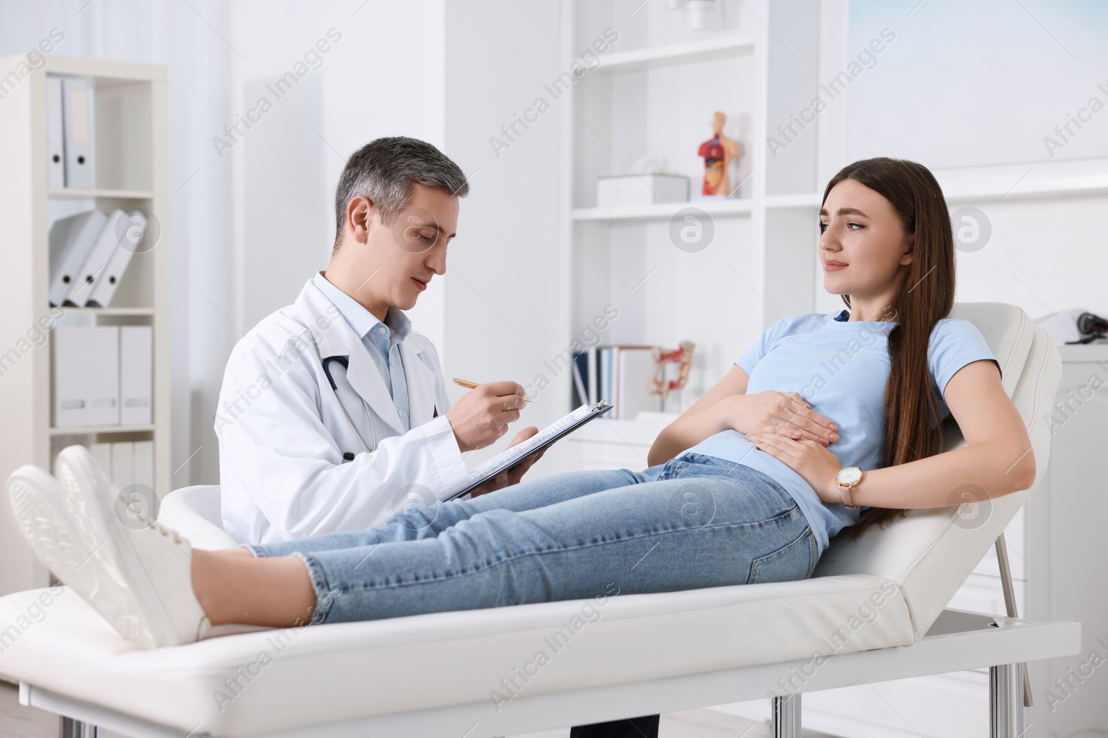 Photo of Gastroenterologist with clipboard consulting patient in clinic