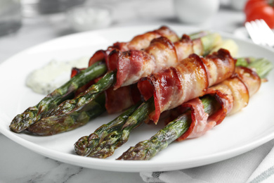 Photo of Oven baked asparagus wrapped with bacon on plate, closeup